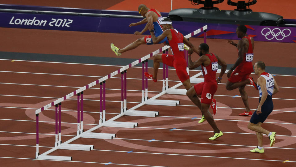 Felix Sanchez (L) of the Dominican Republic clears a hurdle as he competes in the men's 400m hurdles final during the London 2012 Olympic Games at the Olympic Stadium August 6, 2012. REUTERS/Stefan Wermuth (BRITAIN - Tags: OLYMPICS SPORT ATHLETICS) 