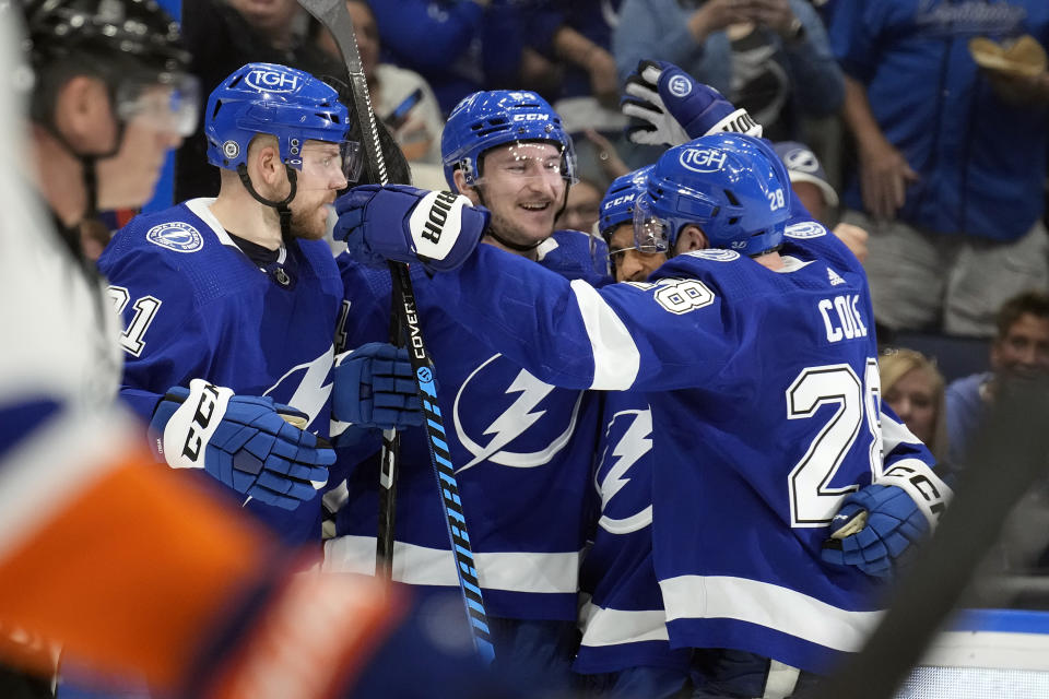 Tampa Bay Lightning left wing Tanner Jeannot, center, celebrates his goal against the New York Islanders with defenseman Erik Cernak, left, and defenseman Ian Cole, right, during the second period of an NHL hockey game Saturday, April 1, 2023, in Tampa, Fla. (AP Photo/Chris O'Meara)