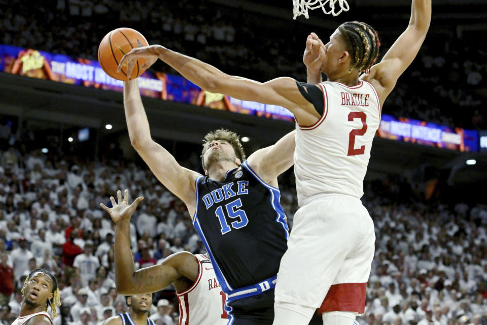 Duke center Ryan Young (15) is fouled as he tries to drive past Arkansas forward Trevon Brazile (2) during the first half of an NCAA college basketball game Wednesday, Nov. 29, 2023, in Fayetteville, Ark. (AP Photo/Michael Woods)