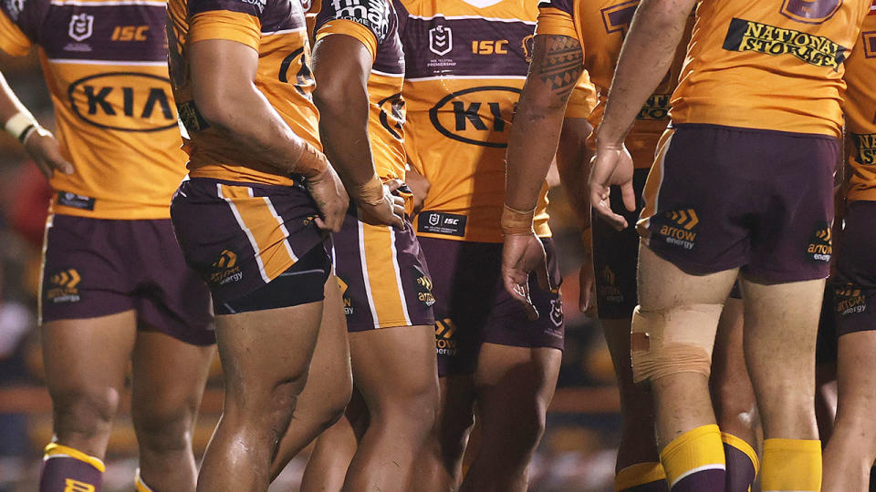 Pictured here, Brisbane Broncos players in a huddle during a match. 