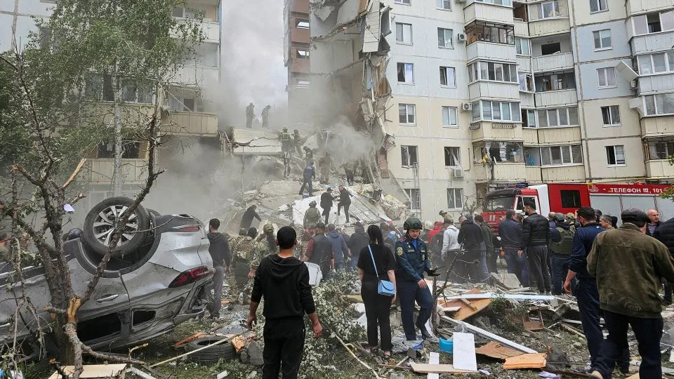 People gather following the collapse of a section of a multi-story apartment block in the city of Belgorod, Russia, on May 12, 2024. - Reuters