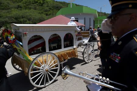 A horse-drawn carriage carries the coffin of Angel Candelario, one of the victims of the shooting at the Pulse night club in Orlando, during his funeral procession in his hometown of Guanica, Puerto Rico, June 18, 2016. REUTERS/Alvin Baez