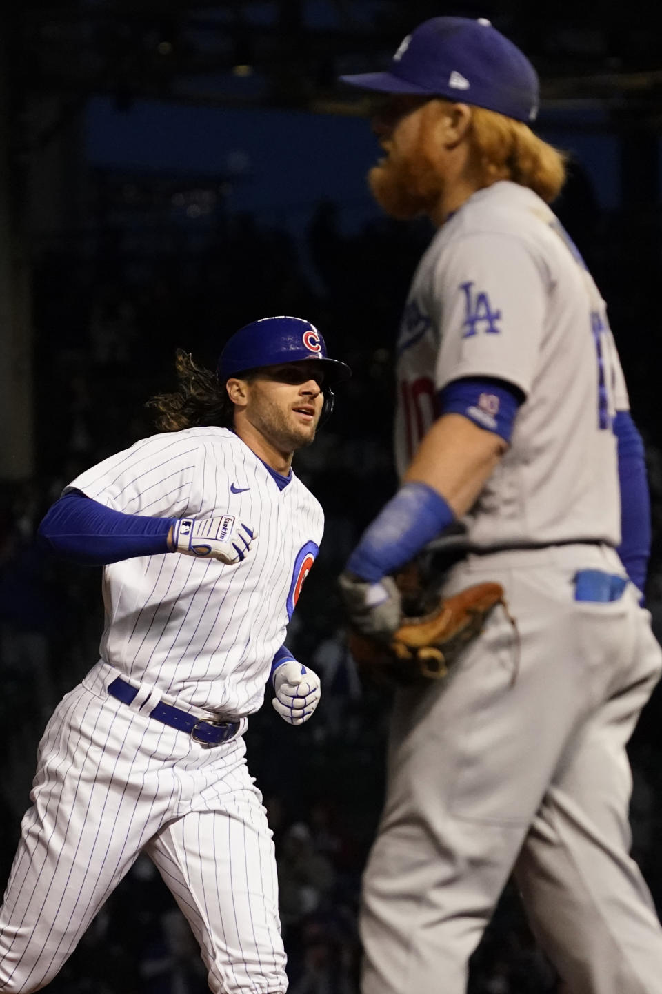 Chicago Cubs' Jake Marisnick, left, rounds the bases after his two-run home run as Los Angeles Dodgers third baseman Justin Turner looks at the score board during the fifth inning of a baseball game in Chicago, Wednesday, May 5, 2021. (AP Photo/Nam Y. Huh)