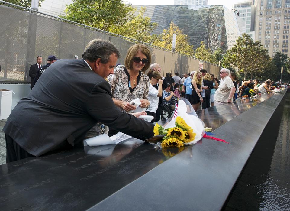 New Jersey governor Chris Christie puts a flower by the name of Walter Philip Travers at the 9/11 Memorial during ceremony marking the 12th Anniversary of the attacks on the World Trade Center in New York September 11, 2013. REUTERS/Ozier Muhammad/Pool