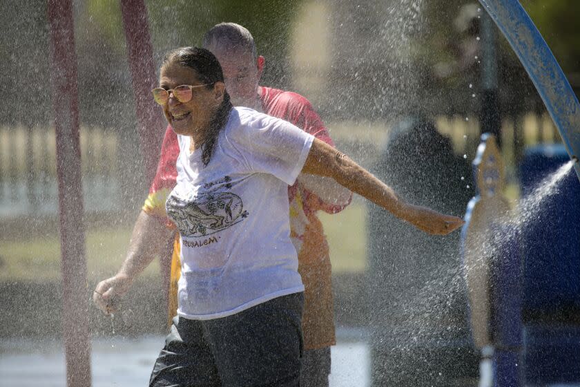 Ontario, CA - September 03: To beat the brutal heat wave that is bearing down on Southern California, with temperatures expected to push into triple-digit temperatures through the Labor Day weekend, Aaron Zaretsky and wife Andrea Zaretsky enjoys cool water spray in the splash pad at Cucamonga-Guasti Regional Park on Saturday, Sept. 3, 2022 in Ontario, CA. (Irfan Khan / Los Angeles Times)