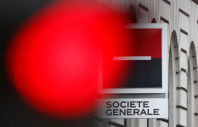 FILE PHOTO: A traffic light shines red near the French bank Societe Generale's logo in Paris