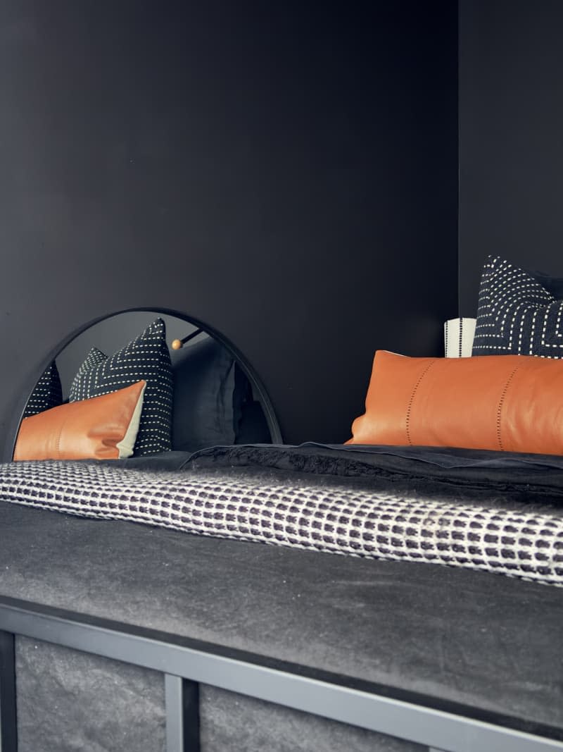 Black bedroom with decorative pillows.