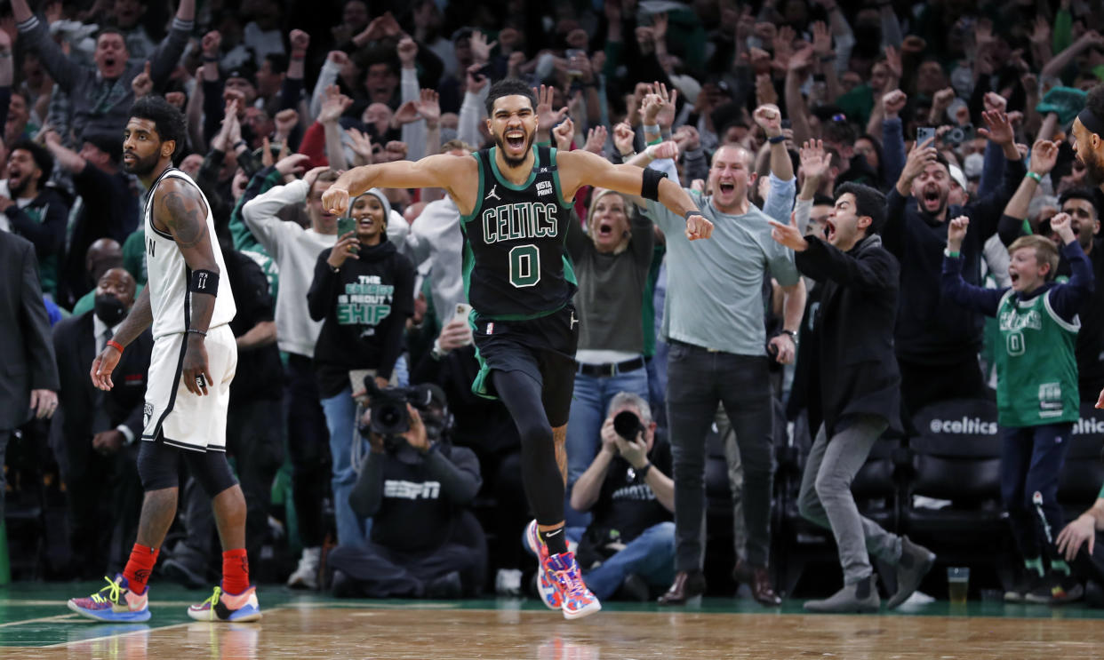 Boston - April 17: The Celtics Jayson Tatum (right) as well as the fans erupt after his basket at the buzzer defeated Kyrie Irving (left) and the Nets 115-114. The Boston Celtics hosted the Brooklyn Nets in Game One of the NBA first round playoff series at the TD Garden in Boston on April 17, 2022. (Photo by Jim Davis/The Boston Globe via Getty Images)