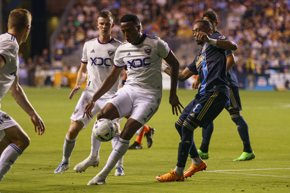 D.C. United's Michael Estrada, center, fields the ball as Philadelphia Union's Jose Martínez, right, defends during the second half of an MLS soccer match Friday, July 8, 2022, in Chester, Pa. The Union won 7-0. (AP Photo/Chris Szagola)