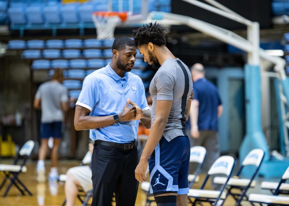 North Carolina staffer Jackie Manuel, left, and senior swingman Leaky Black pause for a quiet moment of reflection together at the Smith Center in Chapel Hill.