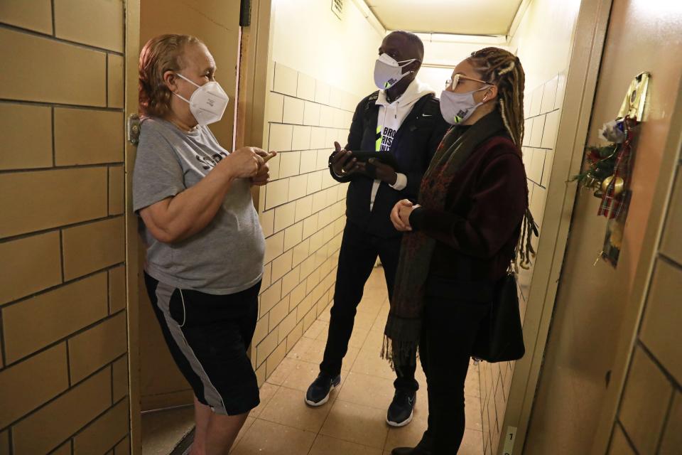 Lynmarie Francisco and Nelson Washington with the Bronx Rising Initiative help register a resident for the COVID-19 vaccination at a Highbridge Gardens public housing building in the Bronx Feb. 24, 2021. The organization is informing residents about the vaccination and making it easier for those eligible to get registered and vaccinated if they'd like. They partnered with Morris Heights Health Community Center to bring a mobile vaccination unit to the apartments for the vaccination.