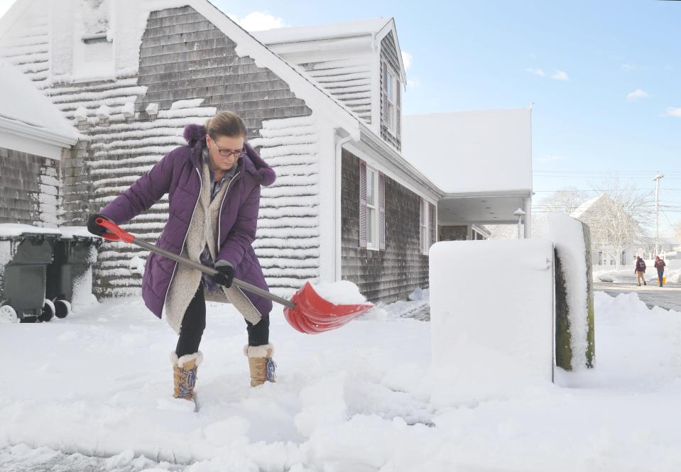 Harwich Chamber of Commerce Executive Director Cyndi Williams shovels snow off the walkway in front of the visitor center Wednesday morning.