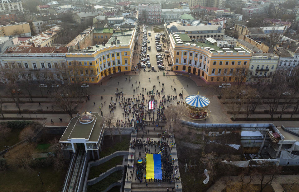 Ukrainians march holding a national flag to celebrate a Day of Unity in Odessa, Ukraine, Wednesday, Feb. 16, 2022. As Western officials warned a Russian invasion could happen as early as today, the Ukrainian President Zelenskyy called for a Day of Unity, with Ukrainians encouraged to raise Ukrainian flags across the country. (AP Photo/Emilio Morenatti)