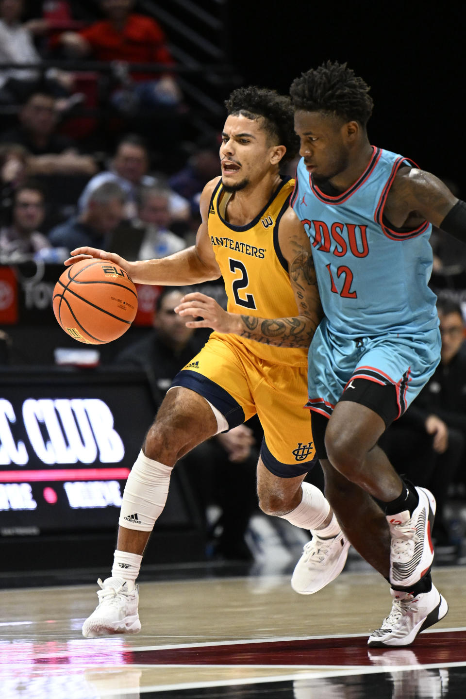 UC Irvine guard Justin Hohn (2) drives past San Diego State guard Darrion Trammell (12) during the first half of an NCAA college basketball game Tuesday, Nov. 29, 2022, in San Diego. (AP Photo/Denis Poroy)