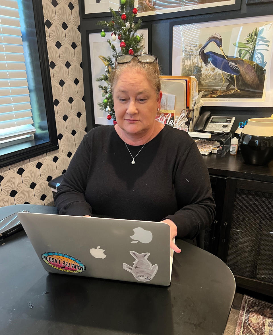 Samantha Martin works on her laptop at home in New York on Dec. 4, 2022. Martin has kept up her pandemic practice of visiting with loved ones at mealtime. (Andre Neyrey via AP)