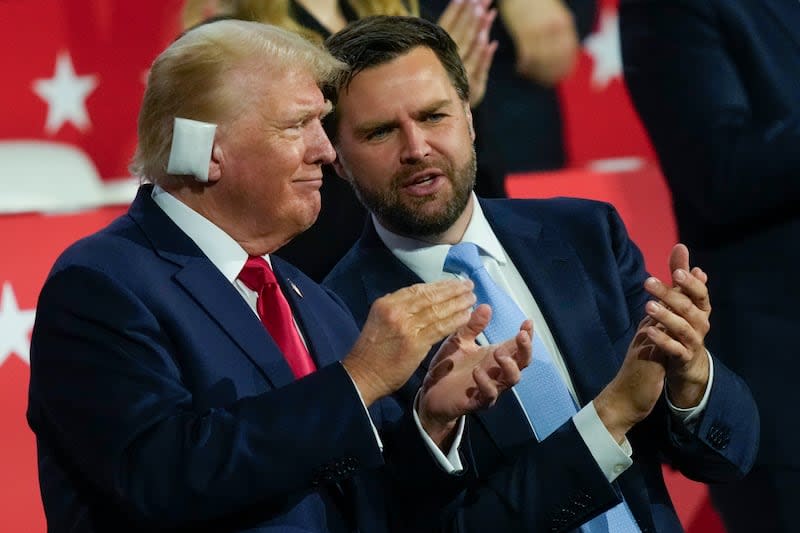 Republican presidential candidate former President Donald Trump talks to Republican vice presidential candidate Sen. JD Vance, R-Ohio, during the Republican National Convention Monday, July 15, 2024, in Milwaukee. | Charles Rex Arbogast