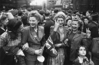 <p>A group of overjoyed Londoners hold up peace signs while celebrating in the streets.</p>