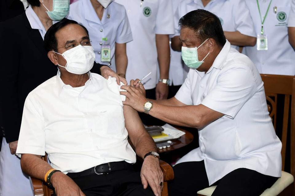 A health worker administers second dose of the AstraZeneca COVID-19 vaccine to Thailand's Prime Minister Prayuth Chan-ocha, left, at Bamrasnaradura Infectious Diseases Institute in Bangkok, Thailand, Monday, May 24, 2021. (Government Spokesman Office via AP)