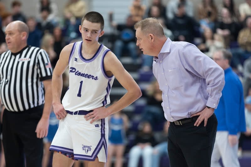 Cooper Lewis, left, listens to his father, coach Quincy Lewis, during a game against Pleasant Grove at Lehi High.