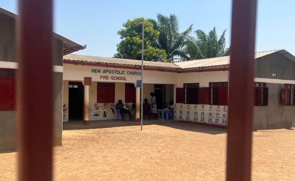 People sit in the shade at a school that is closed by the government due to an extreme heat wave alert for the next days, in Juba, South Sudan