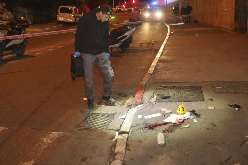 Israeli police officers inspect the scene of an attack in Jerusalem, early Thursday, Feb. 6, 2020. A Palestinian motorist slammed his car into a group of soldiers early on Thursday, wounding more than a dozen before fleeing the scene, Israeli police said. (AP Photo/Mahmoud Illean)