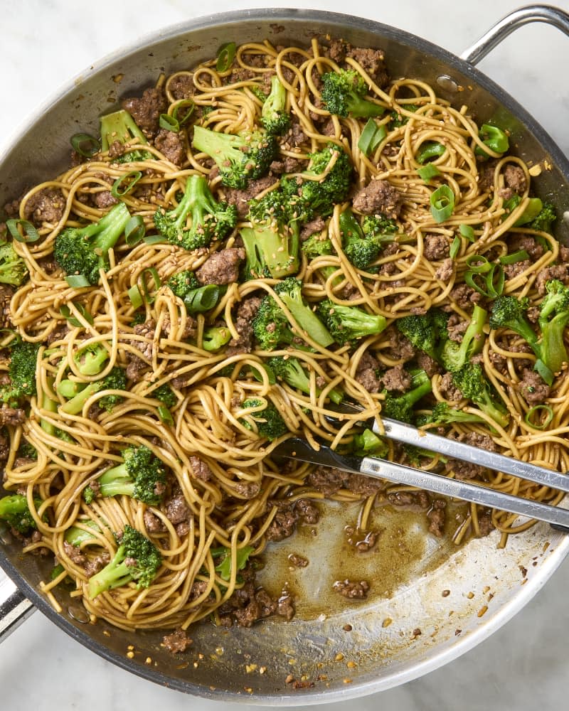 overhead shot of beef and broccoli noodles in a silver pan
