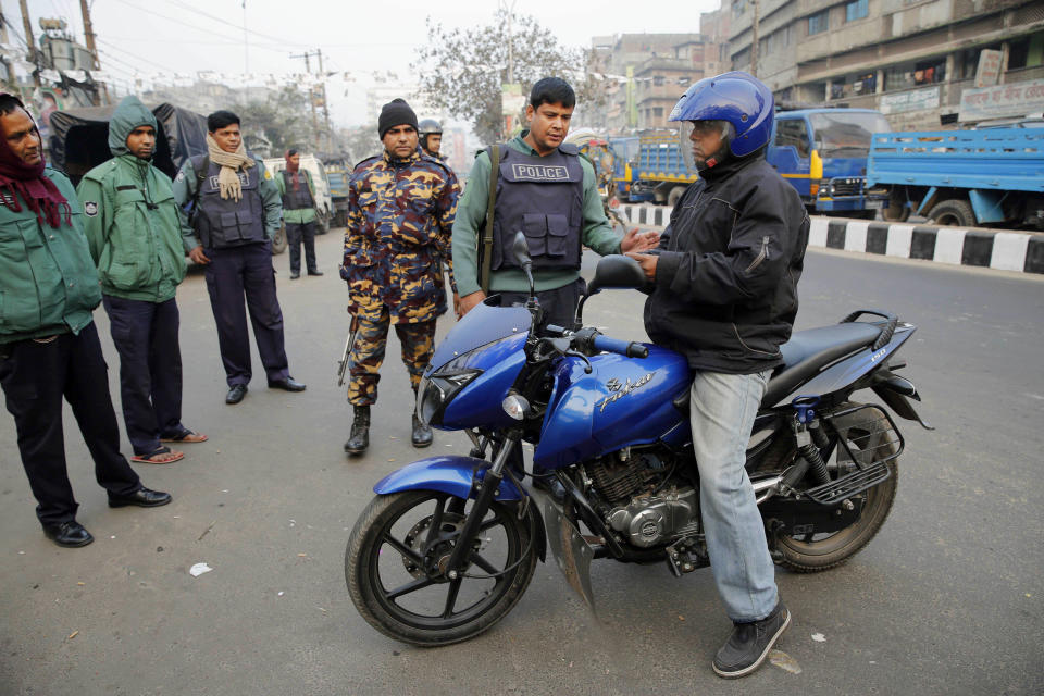 Bangladeshi policemen check a man riding on a motorcycle during a nationwide 48-hour strike called by the main opposition Bangladesh Nationalist Party (BNP) a day before general elections in Dhaka, Bangladesh, Saturday, Jan. 4, 2014. The run-up to Sunday's general election in Bangladesh has been marked by bloody street clashes and caustic political vendettas, and the vote threatens to plunge this South Asian country even deeper into crisis. (AP Photo/Rajesh Kumar Singh)