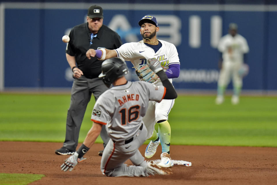 Tampa Bay Rays shortstop José Caballero forces San Francisco Giants' Nick Ahmed (16) at second base and relays the throw to first in time to turn a double play on Jung Hoo Lee during the fifth inning of a baseball game Friday, April 12, 2024, in St. Petersburg, Fla. (AP Photo/Chris O'Meara)