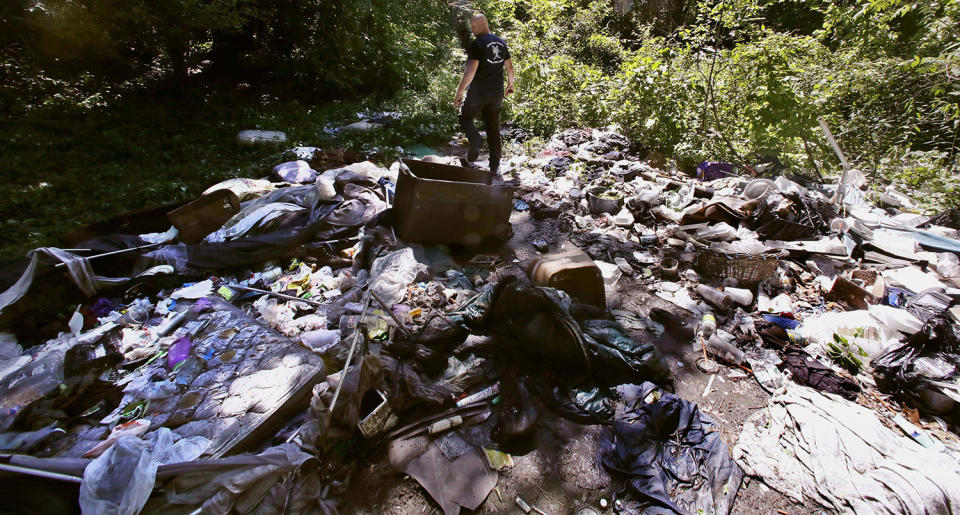 <p>Activist Rocky Morrison walks through an encampment where opioid addicts shoot up along the Merrimack River in Lowell, Mass. Morrison leads a cleanup effort along the Merrimack River, which winds through the old milling city of Lowell, and has recovered hundreds of needles in abandoned homeless camps that dot the banks, as well as in piles of debris that collect in floating booms he recently started setting. (Photo: Charles Krupa/AP) </p>