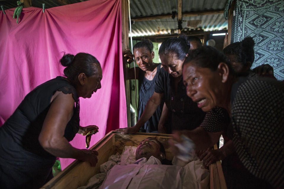 En esta fotografía del 2 de septiembre de 2018, Sonia Willis, izquierda, acompañada por sus familiares, llora sobre el ataúd que contiene los restos de su hijo de 31 años, el buzo misquito Oscar Salomón Charly, durante un velorio en su casa ubicada en Cabo Gracias a Dios, Nicaragua. Miles de hombres han hecho de la pesca por buceo su forma de vida en la Mosquitia, una región de Honduras y Nicaragua enclavada en la costa caribe. Y varios de ellos han sido víctimas del síndrome de descompresión, un padecimiento por el que se forman burbujas de nitrógeno en el cuerpo de los buzos y puede causar parálisis o incluso la muerte. (AP Foto/Rodrigo Abd)