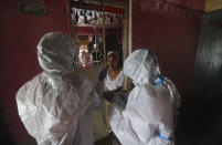 Health workers screen people for COVID-19 symptoms at a residential building in Dharavi , one of Asia's biggest slums, in Mumbai, India, Friday, Aug. 7, 2020. As India hit another grim milestone in the coronavirus pandemic on Friday, crossing 2 million cases and more than 41,000 deaths, community health volunteers went on strike complaining they were ill-equipped to respond to the wave of infection in rural areas. (AP Photo/Rafiq Maqbool)