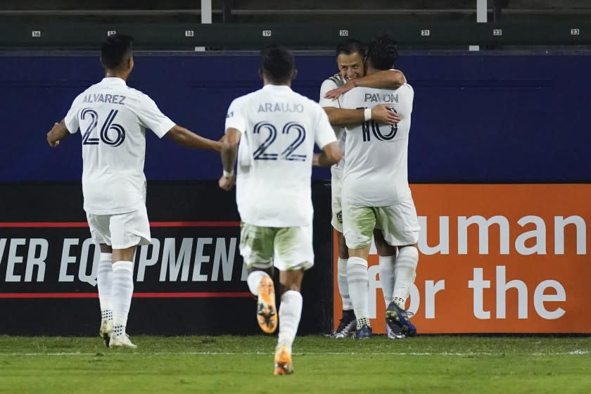 LA Galaxy forward Javier Hernandez, second from right, celebrates with midfielder Efrain Alvarez (26), defender Julian Araujo (22), and forward Cristian Pavon (10) after scoring a goal during the second half of the team's MLS soccer match against the Seattle Sounders on Wednesday, Nov. 4, 2020, in Carson, Calif. (AP Photo/Ashley Landis)