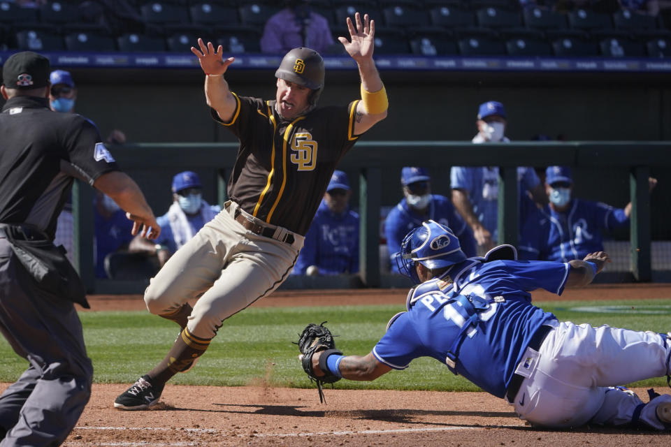 San Diego Padres' Patrick Kivlehan, left, avoids a tag by Kansas City Royals catcher Salvador Perez to score on a single by Brian O'Grady during the sixth inning of a spring training baseball game Monday, March 22, 2021, in Surprise, Ariz. (AP Photo/Sue Ogrocki)