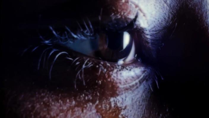 Close up picture of woman&#39;s eye with a tear drop falling on her lower eyelid.