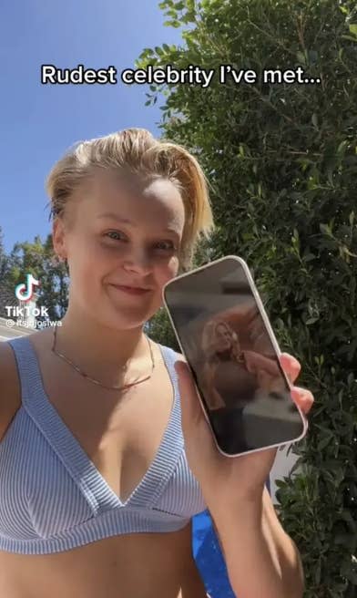 JoJo holding up her phone with a picture of Candace