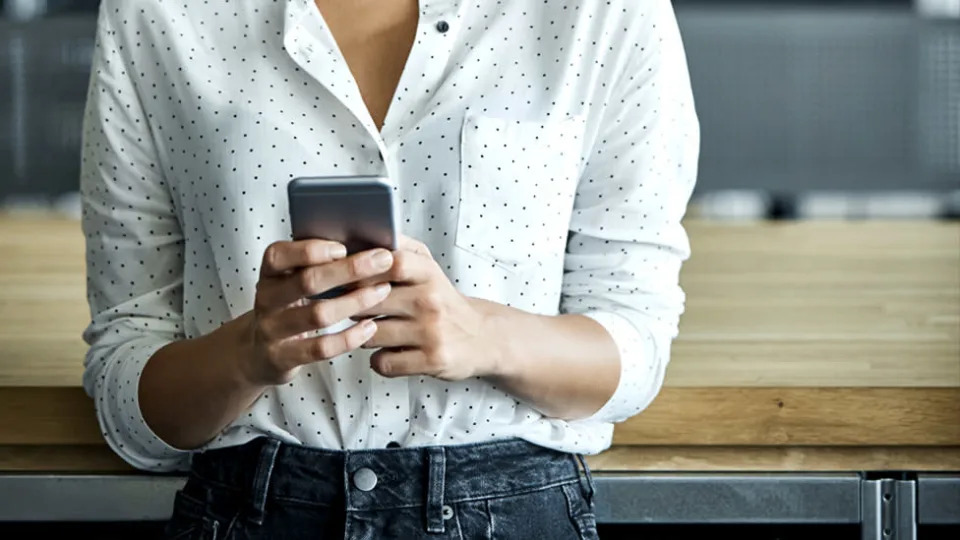 A stock image of a woman looking at a mobile phone