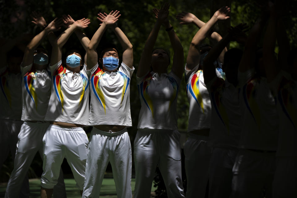 Workers wearing face masks to protect against COVID-19 do group exercises at a park in Beijing, Tuesday, May 25, 2021. (AP Photo/Mark Schiefelbein)