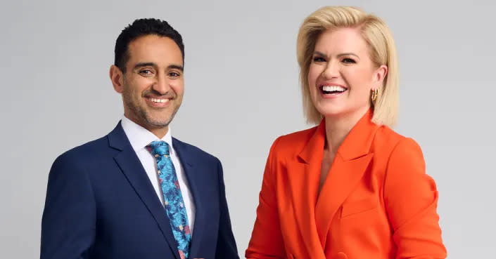 Waleed Aly and Sarah Harris stand side-by-side smiling. 