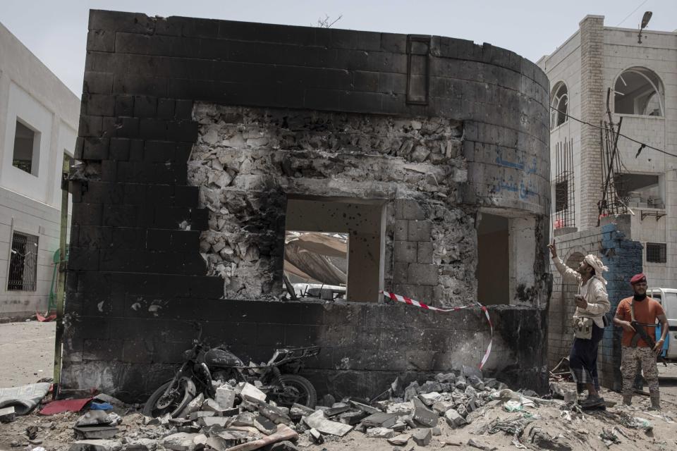 Security forces inspect the site of a deadly attack in Aden, Yemen, Thursday, Aug. 1, 2019. Yemen's rebels fired a ballistic missile at a military parade Thursday in the southern port city of Aden as coordinated suicide bombings targeted a police station in another part of the city. The attacks killed over 50 people and wounded dozens. (AP Photo/Nariman El-Mofty)