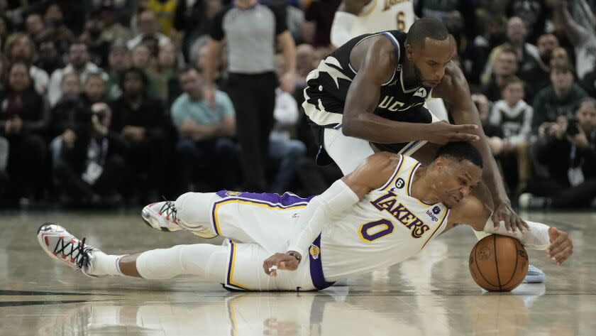 Milwaukee Bucks' Khris Middleton and Los Angeles Lakers' Russell Westbrook go after a loose ball during the second half of an NBA basketball game Friday, Dec. 2, 2022, in Milwaukee. (AP Photo/Morry Gash)