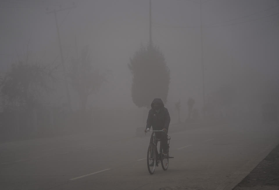 A man pedals his bicycle enveloped by dense fog on a cold morning in Srinagar, Indian controlled Kashmir, Wednesday, Nov. 15, 2023. (AP Photo/Mukhtar Khan)