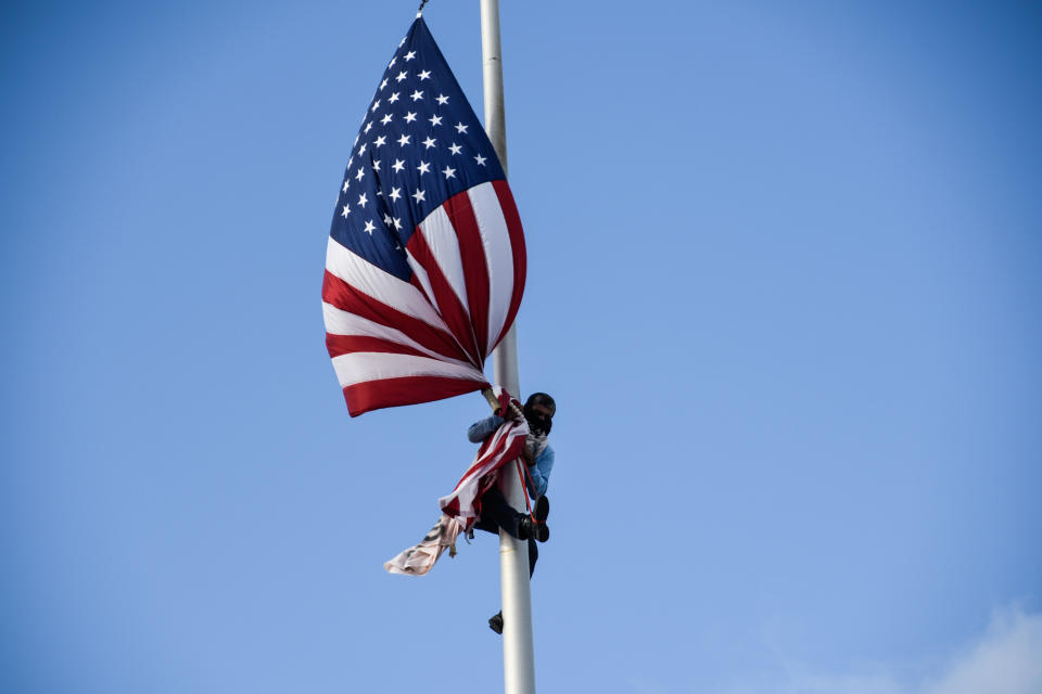 Puerto Rican environmental activist Tito Kayak climbs the pole in front of the capitol building to take down the flag of USA during the fifth day of protests calling for the resignation of Governor Ricardo Rossello in San Juan, Puerto Rico July 17, 2019. (Photo: Gabriella N. Baez/Reuters)