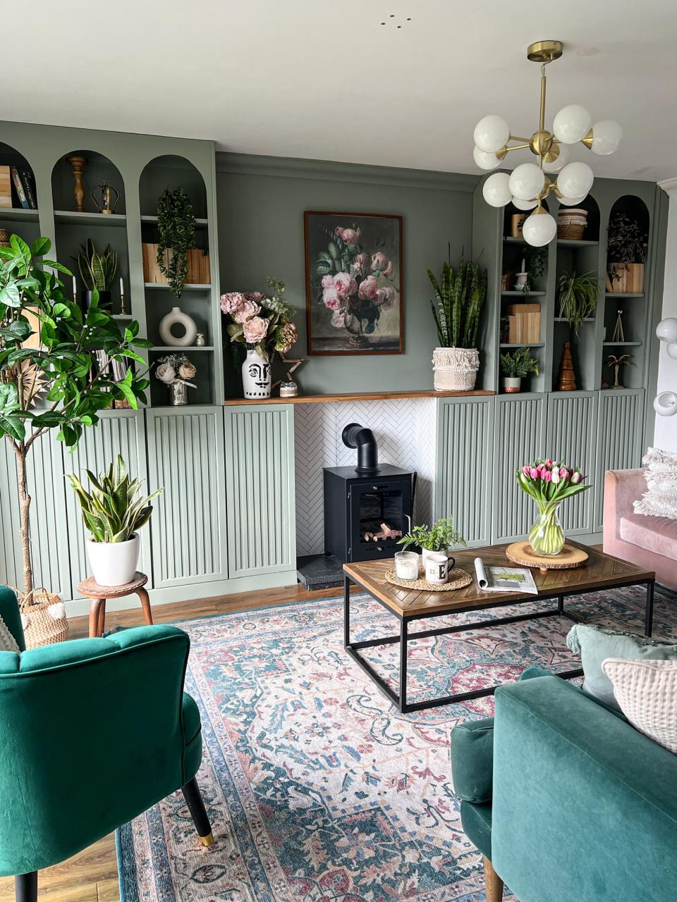 A living room with a built in bookcase painted sage green
