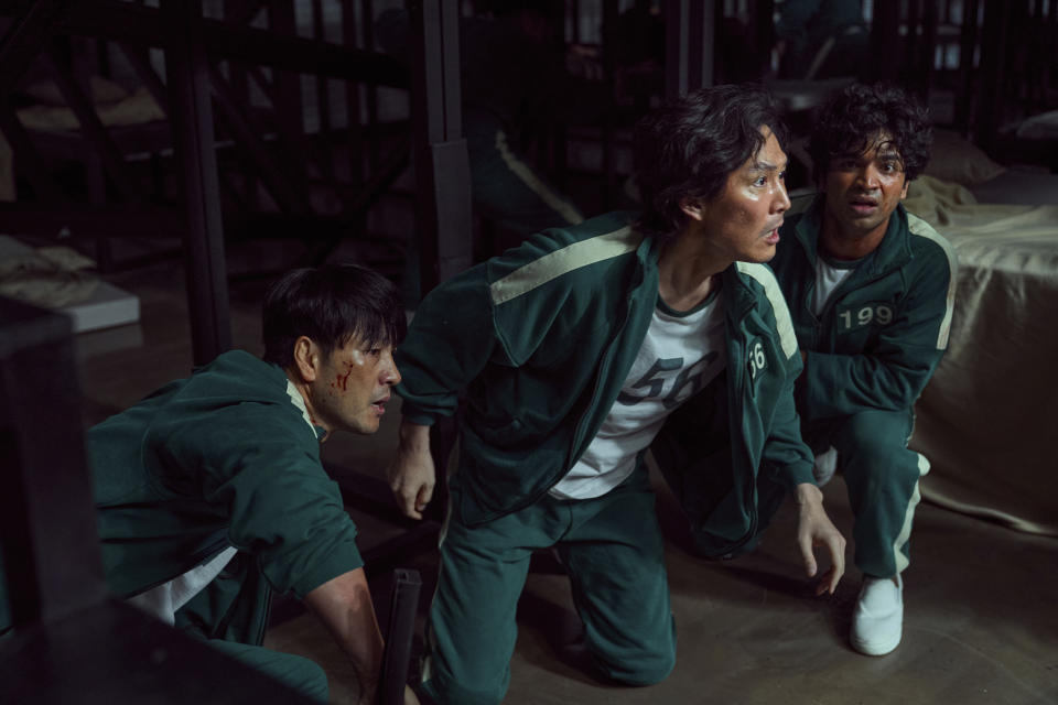 This undated photo released by Netflix shows South Korean cast members, from left, Park Hae-soo, Lee Jung-jae and Anupam Tripathi in a scene from "Squid Game." Squid Game, a globally popular South Korea-produced Netflix show that depicts hundreds of financially distressed characters competing in deadly children’s games for a chance to escape severe debt, has struck a raw nerve at home, where there’s growing discontent over soaring household debt, decaying job markets and worsening income inequality. (Youngkyu Park/Netflix via AP)