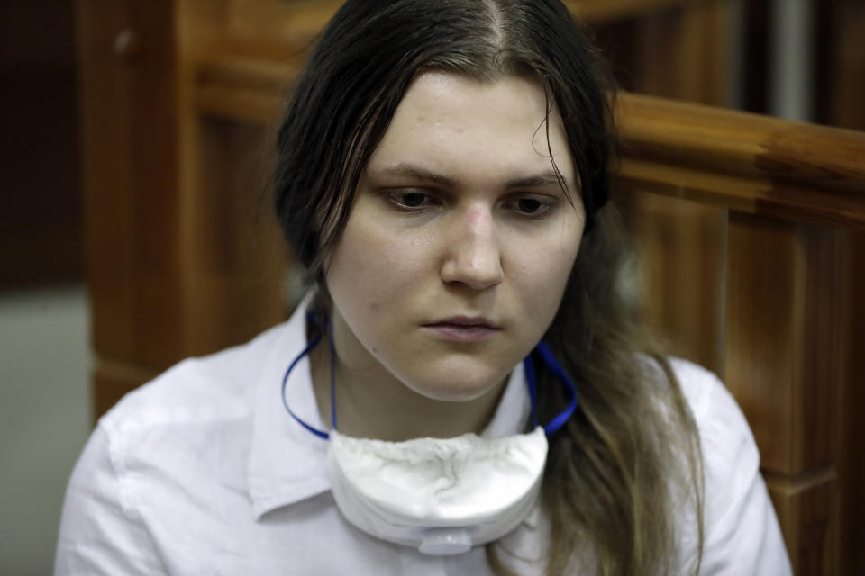 Anna Pavlikova, a member of the New Greatness group who are charged with the organisation of an extremist association, sits in a courtroom prior to a court hearing in Moscow, Russia, Tuesday, July 14, 2020. Arrests of the two youngest members — 17-year-old Anna Pavlikova and 19-year-old Maria Dubovik — prompted a mass protest in August 2018, after which the two teenagers were released under house arrest. (AP Photo/Pavel Golovkin)