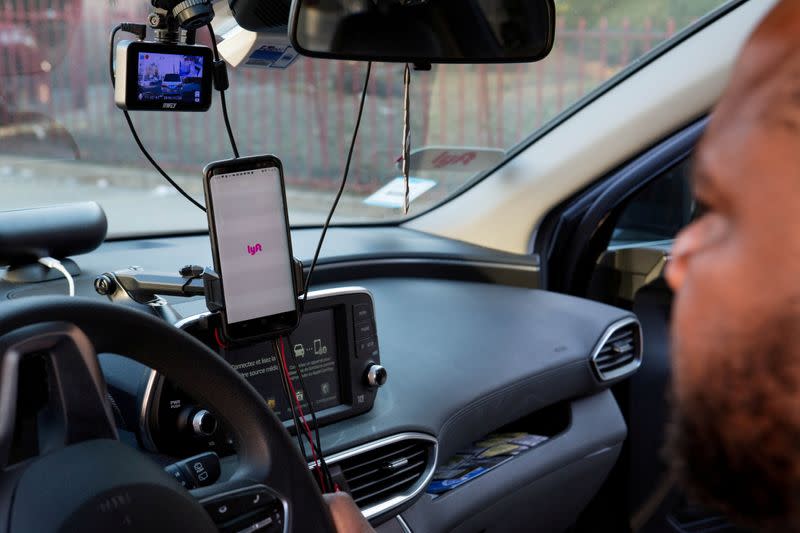 FILE PHOTO: Uber and Lyft driver Adama Fofana sits in his car in New York City