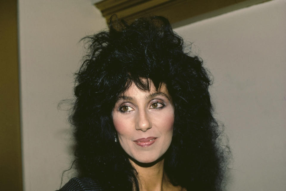 Cher smirking while looking away from camera