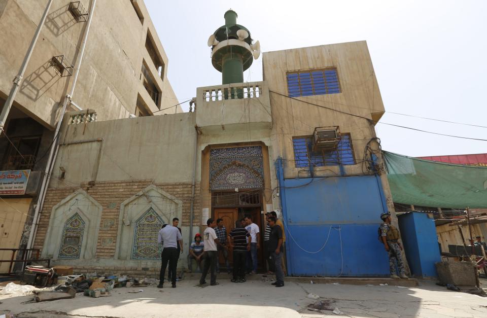 People gather at the site of a suicide bomber on a Shi'ite mosque in Baghdad May 27, 2014. (REUTERS/Thaier Al-Sudani)