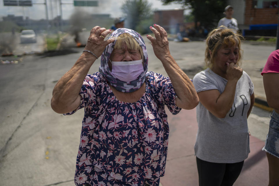 Lucia Galloso, 67, protests the arrest of residents in the Puerta 8 suburb north of Buenos Aires, Argentina, where police say contaminated cocaine may have been sold, Friday, Feb. 4, 2022. A batch of cocaine has killed at least 23 people and hospitalized many more in Argentina, according to police. (AP Photo/Rodrigo Abd)