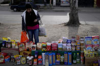 A shopper looks at food displayed at a market where clients can buy or barter on the outskirts of Buenos Aires, Argentina, Wednesday, Aug. 10, 2022. Argentina has one of the world’s highest inflation rates, currently running at more than 60% annually, according to the National Institute of Statistics and Census of Argentina (INDEC).